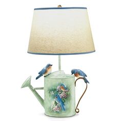 a lamp with two blue birds on it and a watering can underneath the lamp shade