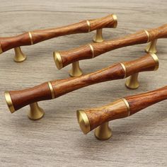 six wooden handles with brass knobs on a table