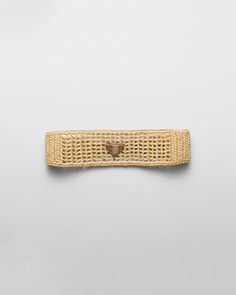 a piece of woven material with a wooden heart on the end, against a white background