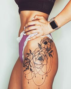 a woman's stomach with tattoos on it and flowers in the bottom part of her body