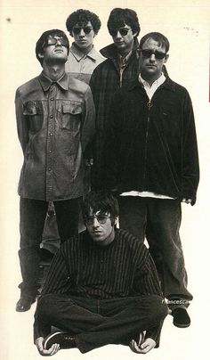 a group of men standing next to each other in front of a white background,