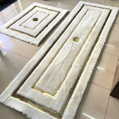 two white rugs sitting on top of a tiled floor next to each other in a room