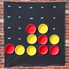 a game made out of plastic cups on a black and red background with white squares