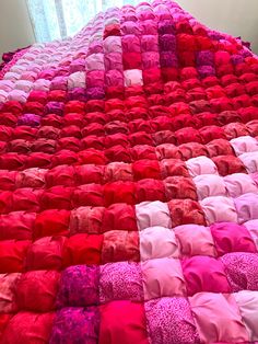 a bed covered in pink and red blankets