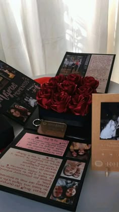 a table topped with pictures and flowers next to a card case filled with cards on it