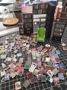 a pile of small pieces of paper sitting on top of a table next to a bookshelf