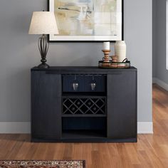 a black cabinet with a wine bottle on it and a lamp in front of it