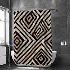 a black and white shower curtain with an abstract design in the middle, on a bathroom floor