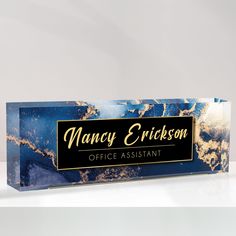 a blue and gold business card holder on a white surface with the name fancy ericson office assistant