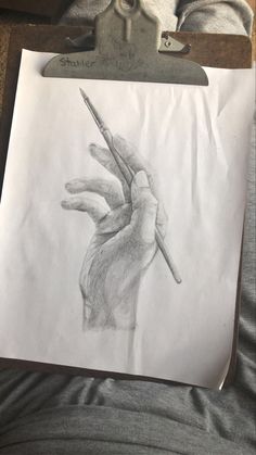 a drawing of a hand holding a pencil in it's right hand, on top of a piece of paper