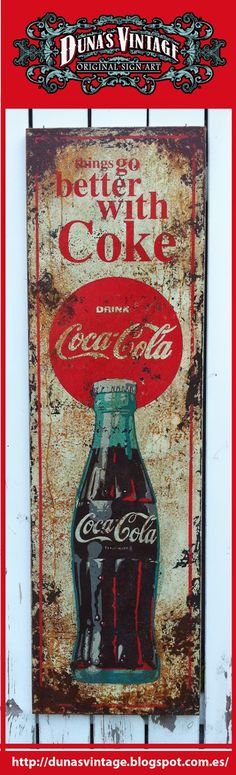 an old coca cola sign is hanging on the wall