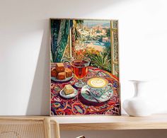 a painting is hanging on the wall above a table with coffee and pastries in front of it