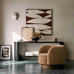 a living room with an art piece on the wall and a chair next to it