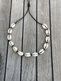 This Cowrie Shell Necklace is our Best Seller! Cowrie shells are known to bring power and good fortune. Our cowrie shell choker necklace is made with all natural cowrie shells and a wax cord. The necklace can be adjusted to your preferred size from 13 -21 inches. Fits children and adults. The necklace is available in a black or beige cord. Automatic Free Shipping on orders over $35! Perfect for a special gift or for yourself. Please read my shop policy before placing your order. Thank you for vi Shell-shaped Jewelry With Adjustable Cord As Gift, Adjustable Shell-shaped Jewelry Cord As A Gift, Handmade Adjustable Shell-shaped Necklaces, Adjustable Shell Necklaces, Adjustable Shell Choker For Gift, Adjustable Shell Choker Gift, Adjustable Shell Choker As Gift, Adjustable Shell Choker Perfect As A Gift, Adjustable Shell-shaped Shell Jewelry