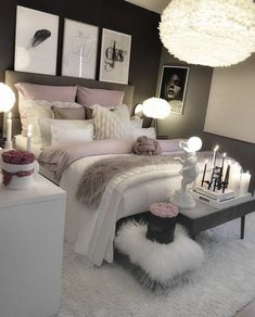 a white bed sitting in a bedroom next to two lamps and pictures on the wall