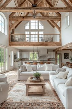 a living room filled with white furniture and lots of wooden beams on the ceiling,