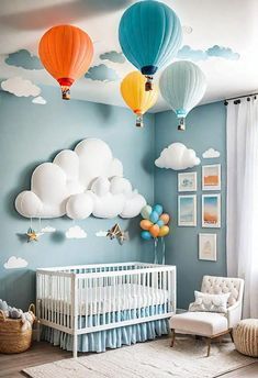 a baby's room decorated in blue and white with hot air balloons above the crib