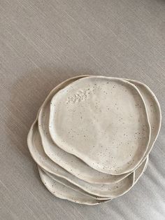 four white plates stacked on top of each other in the shape of three circles, with speckles