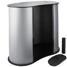 a black and silver trash can next to a remote control