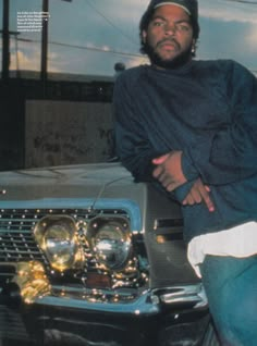 a man leaning on the hood of a car