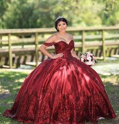 a woman in a red ball gown posing for the camera