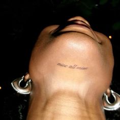 the back of a woman's head with a small tattoo on her left side