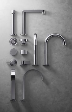 an assortment of stainless steel kitchen faucets and accessories on a gray background with space for text