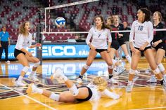 a group of women playing volleyball on a court