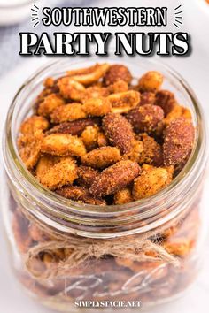 a glass jar filled with party nuts on top of a table