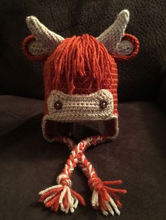 a knitted red and white hat with horns on it's head sitting on a couch