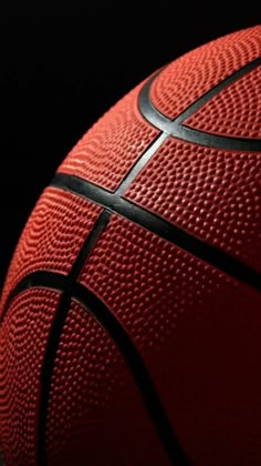 a close up view of a basketball ball with black lines on the outside and red inside