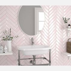 a white sink sitting under a bathroom mirror next to a shelf filled with towels and vases