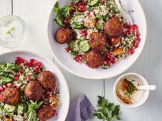 two white bowls filled with meatballs and veggies on top of a table