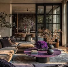 a living room filled with lots of furniture and flowers on top of a coffee table