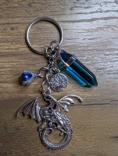 a dragon keychain with a crystal bead hanging from it's side