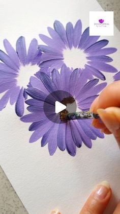 someone is painting purple flowers on white paper