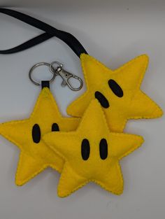 two yellow star shaped keychains with black eyes