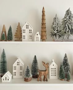 christmas trees and houses are displayed on shelves