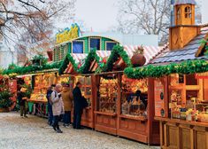 people are standing in line at an outdoor market with christmas decorations on the walls and roof