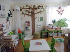 a child's room with green furniture and a tree decal on the wall