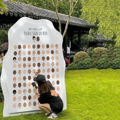 a woman kneeling down next to a giant white board with lots of circles on it