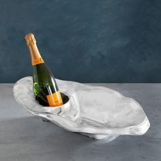 a bottle of champagne sitting on top of an ice tray