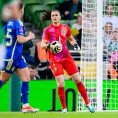 a female soccer player in action on the field with her ball and fans watching from the stands