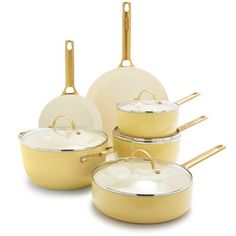 a set of yellow pots and pans with gold handles