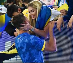 a woman is hugging a man at a soccer game