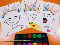 two children's faces are drawn on paper with watercolors and paintbrushes