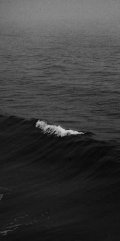 a person riding a surfboard on top of a wave in the middle of the ocean