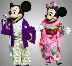 two mickey and minnie mouse costumes standing next to each other