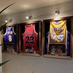 three framed basketball jerseys are hanging on the wall