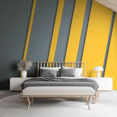 a modern bedroom with yellow and grey stripes on the wall, bed in foreground